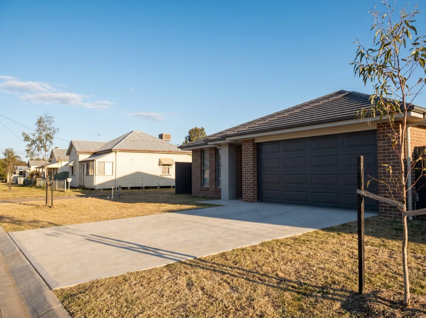 A new charcoal sectional garage door on a new brick home in a growth estate street